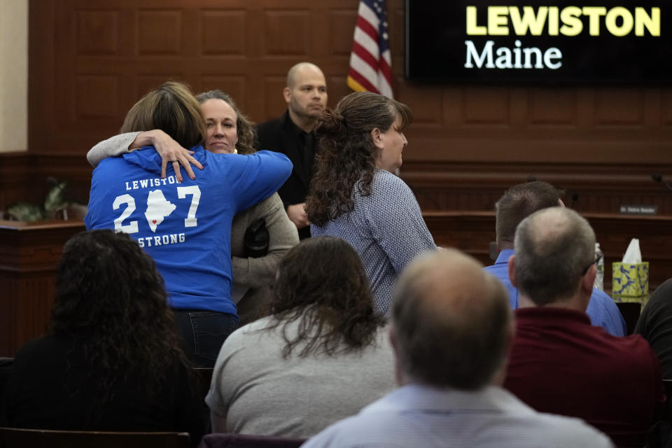 Shooting survivor Danielle Grondin embraces fellow shooting survivor Tammy Asselin, wearing a "Lewiston Strong" shirt, prior to a public meeting with a commission investigating the October 2023 shootings, Monday, March 4, 2024, in Lewiston, Maine. (AP Photo/Charles Krupa)