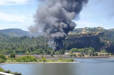 Smoke billows from a derailed oil train near Mosier, Oregon U.S. in this handout photo released to Reuters June 3, 2016. Courtesy of Columbia Riverkeeper/Handout via REUTERS