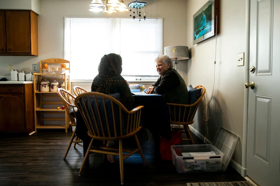 Peg Bouska, right, goes over an English lesson with Rukhsar Azizi at their home in Iowa City.