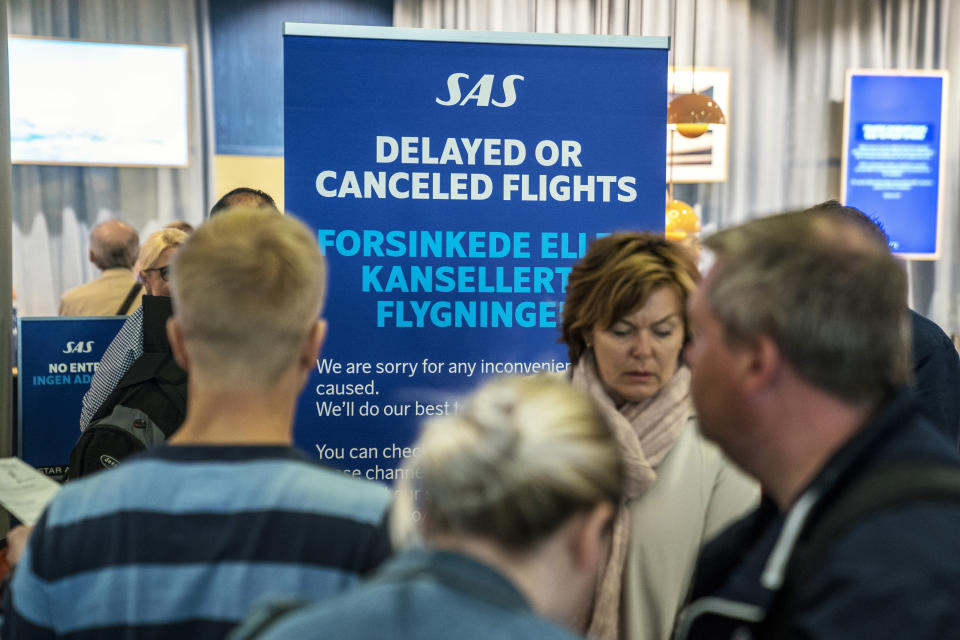 People queue after flights were cancelled by Scandinavian Airlines, at Oslo Airport in Gardermoen, Norway, Friday, April 26, 2019. Pilots for Scandinavian Airlines have launched an open-ended strike following the collapse of pay negotiations, forcing the company to cancel almost all its flights. (Ole Berg-Rusten/NTB Scanpix via AP)