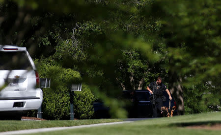 A Secret Service officer walks with his dog on the North Lawn in reaction to an apparent fence jumper at the White House in Washington, U.S., May 16, 2017. REUTERS/Joshua Roberts