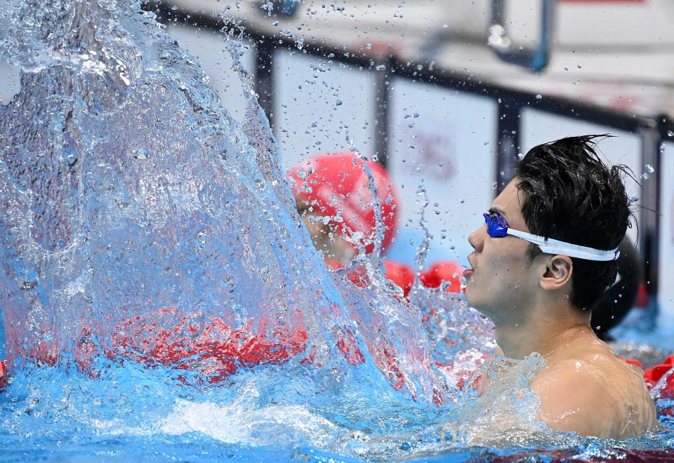 <p>China's Wang Shun celebrates winning to take gold in the final of the men's 200m individual medley swimming event during the Tokyo 2020 Olympic Games at the Tokyo Aquatics Centre in Tokyo on July 30, 2021. (Photo by Attila KISBENEDEK / AFP)</p> 