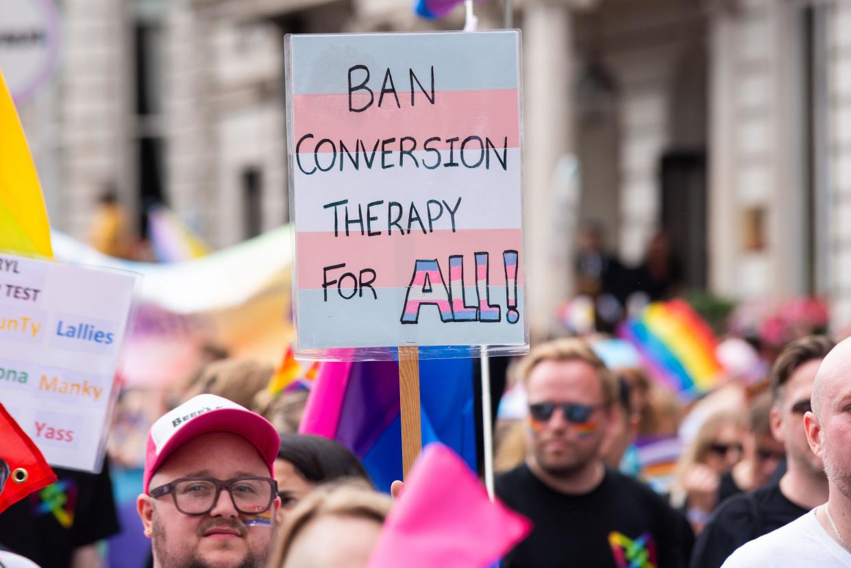Ban conversion therapy protest placard at Pride in London 2023, celebration of LGBT+. Trans flag colours
