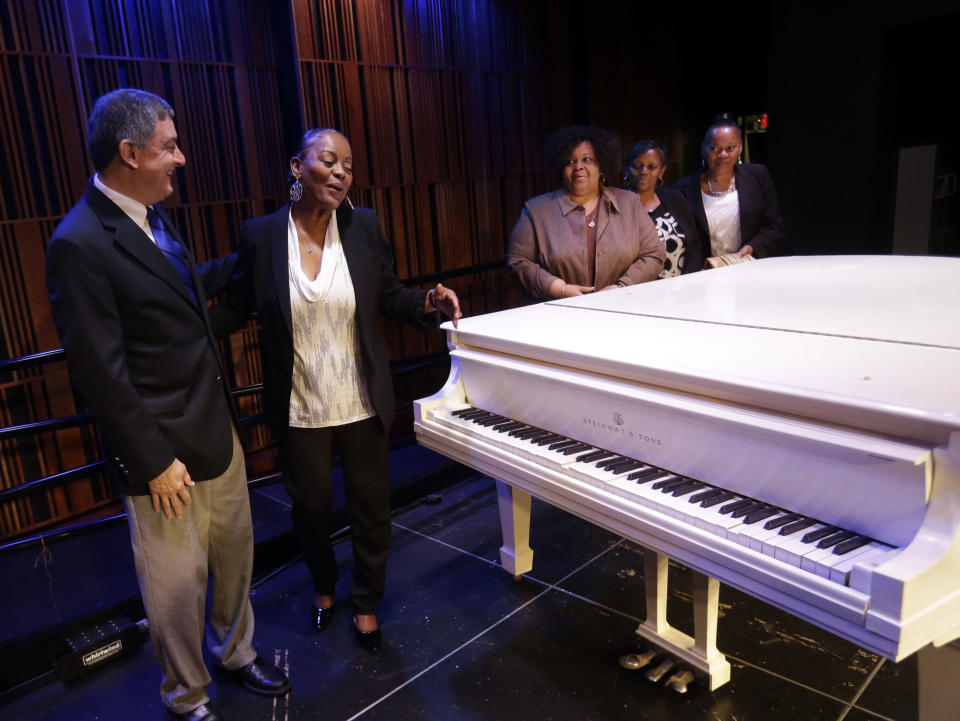 Louisiana Lt. Gov. Jay Dardenne, left, shows off a white Steinway grand piano, salvaged from the flooded Lower 9th Ward home of legendary musician Fats Domino after Hurricane Katrina, after being restored in New Orleans, Thursday, May 2, 2013. With him are Domino's daughters, left to right, Andrea Brimmer, Antoinette Smith, Anola Hartzog, and Adonica Domino. Its restoration came through $30,000 donated to the Louisiana Museum Foundation, and will be the centerpiece of an exhibit in the French Quarter. (AP Photo/Gerald Herbert)