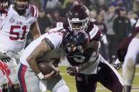 Mississippi quarterback Matt Corral (2) is corralled by Mississippi State defensive end Randy Charlton (5) during the first half of an NCAA college football game Thursday, Nov. 25, 2021, in Starkville, Miss. (AP Photo/Rogelio V. Solis)