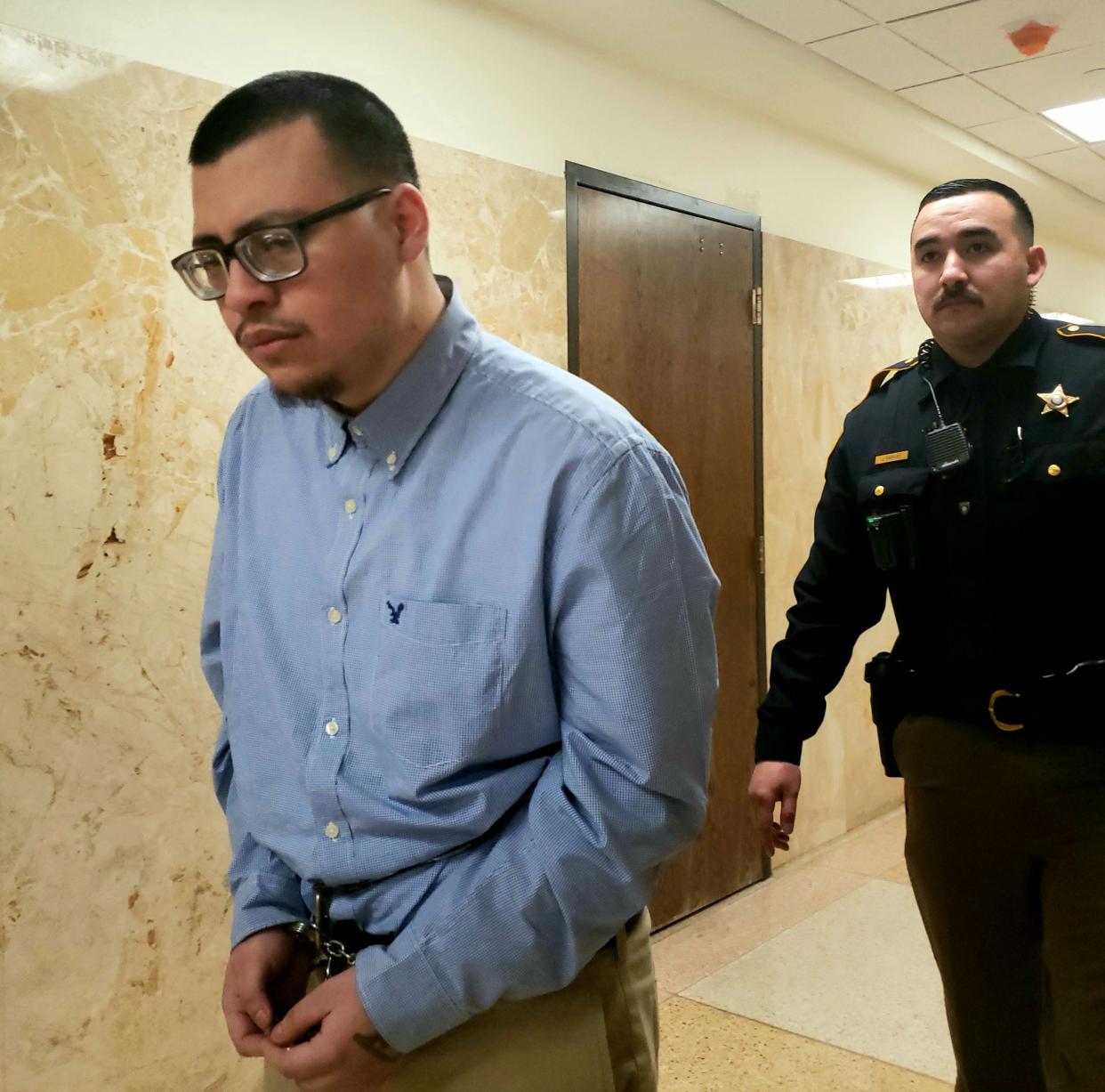 Luis Munoz is escorted out of the 140th District Court where a jury sentenced him to 99 years in prison in connection with a 2020 shooting during an armed robbery that left a man paralyzed from the chest down.