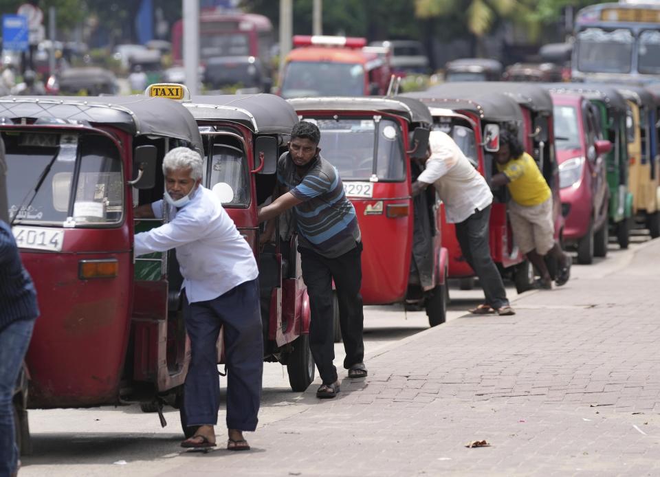 FILE- Sri Lankan auto rickshaw drivers queue up to buy petrol near a fuel station in Colombo, Sri Lanka, Wednesday, April 13, 2022. China says its initiative to build ports and other infrastructure paid for with Chinese loans across Asia and Africa will boost trade. But in a cautionary tale for other borrowers, Sri Lanka's debt to Beijing threatens to hold back efforts to resolve a financial crisis so severe that this Indian Ocean nation cannot import food or gasoline. (AP Photo/Eranga Jayawardena, File)