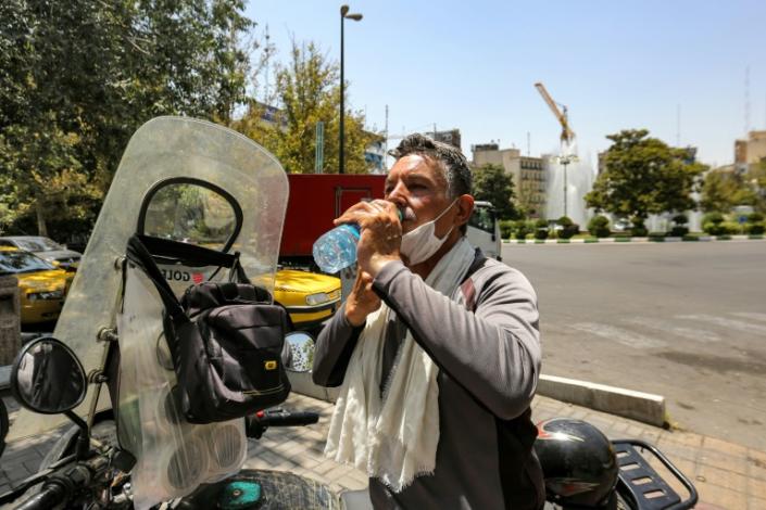 A motorcyclist takes a break in the heat of Tehran on July 11, 2023 (ATTA KENARE)