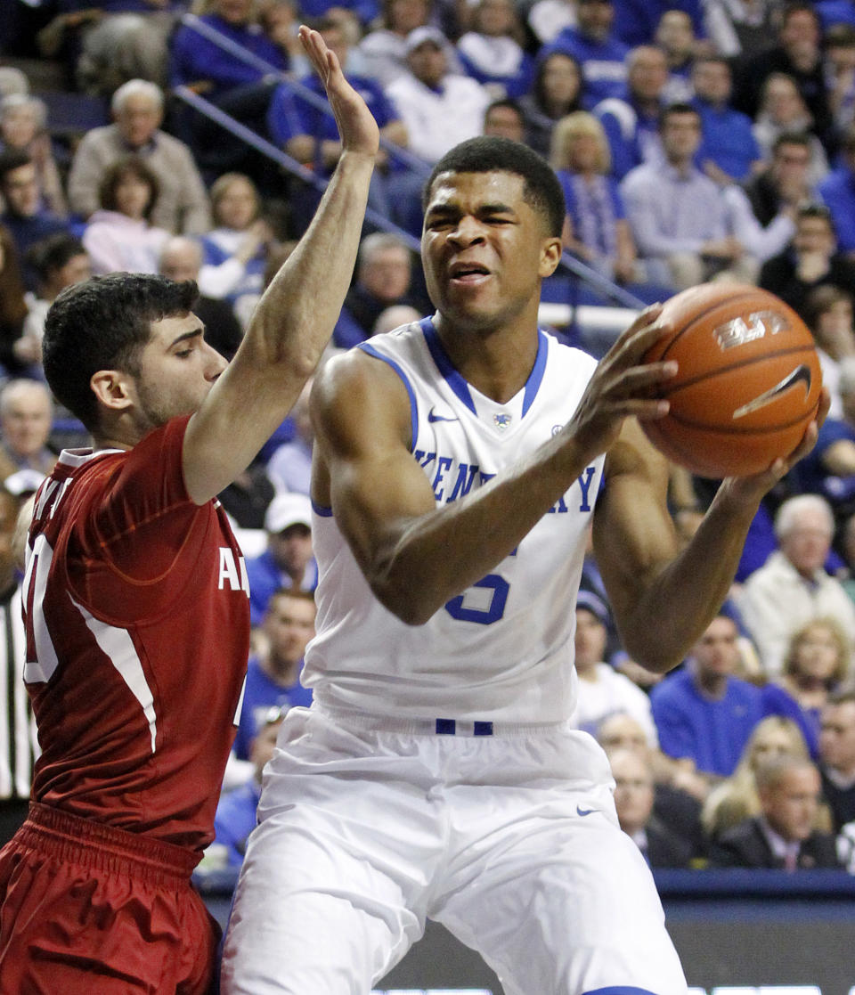 Kentucky's Andrew Harrison (5) is pressured by Arkansas' Kikko Haydar during the first half of an NCAA college basketball game Thursday, Feb. 27, 2014, in Lexington, Ky. (AP Photo/James Crisp)