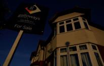FILE PHOTO: A ‘For Sale” sign is seen outside a residential house during sunrise in London