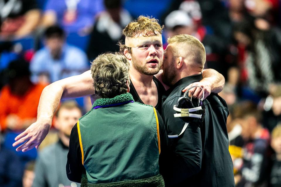 Iowa's Jacob Warner, center, is embraced by coaches Terry Brands, left, and Ryan Morningstar after finishing fifth at 197 pounds at the NCAA Wrestling Championships on Saturday in Tulsa, Okla.