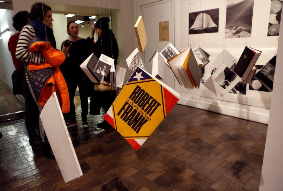 Copies of books by photographer and filmmaker Robert Frank hang from the ceiling at the opening of an exhibition featuring his work, "Robert Frank: Books and Films, 1947–2016," at New York University's Tisch School of the Arts in this file photo taken on Thursday, Jan. 28, 2016, in New York.  