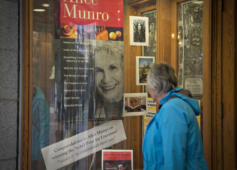 FILE PHOTO: Customer looks at a window display congratulating Canadian author Munro at bookstore Munro's Books after she won Nobel Prize for Literature in Victoria, British Columbia