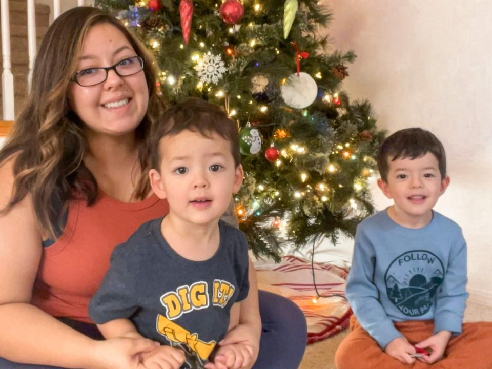 Karissa Whitman sitting below the family Christmas tree with her sons.