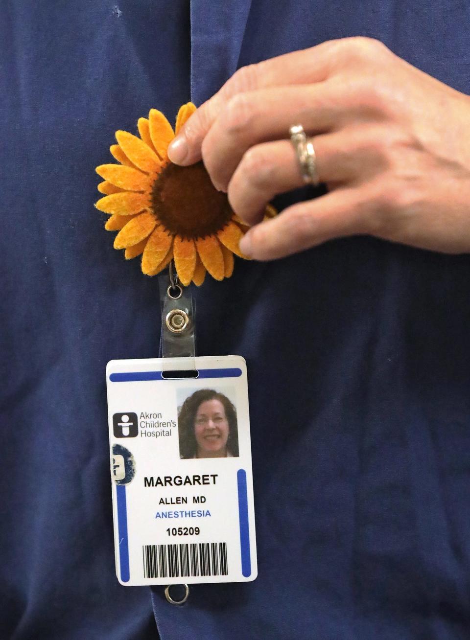 Dr. Peggy Allen shows her support for those struggling in Ukraine by wearing a sunflower pin on her name tag at Akron Children's Hospital on Wednesday.. In Ukraine, the sunflower is used as a symbol of peace.