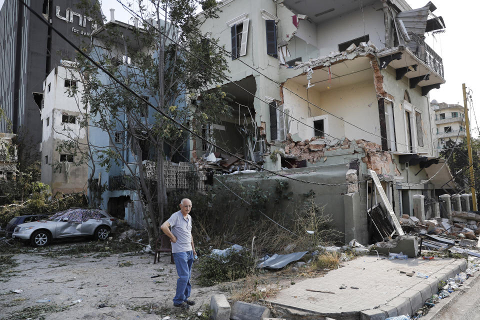 A Lebanese man stands next to his damaged house near the scene where an explosion hit on Tuesday the seaport of Beirut, Lebanon, Thursday, Aug. 6, 2020. Lebanese army bulldozers plowed through wreckage to reopen roads around Beirut's demolished port on Thursday as the government pledged to investigate the devastating explosion and placed port officials under house arrest. (AP Photo/Hussein Malla)