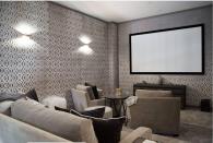 <p>Sure, basements are dark and quiet, which makes them all the better for a home cinema! This one by designer <a href="http://kishaniperera.com/" rel="nofollow noopener" target="_blank" data-ylk="slk:Kishani Perera;elm:context_link;itc:0;sec:content-canvas" class="link ">Kishani Perera</a> eliminates the dungeon-like quality of a dark movie theater with light-colored sofas and armchairs and a patterned wall covering.</p>