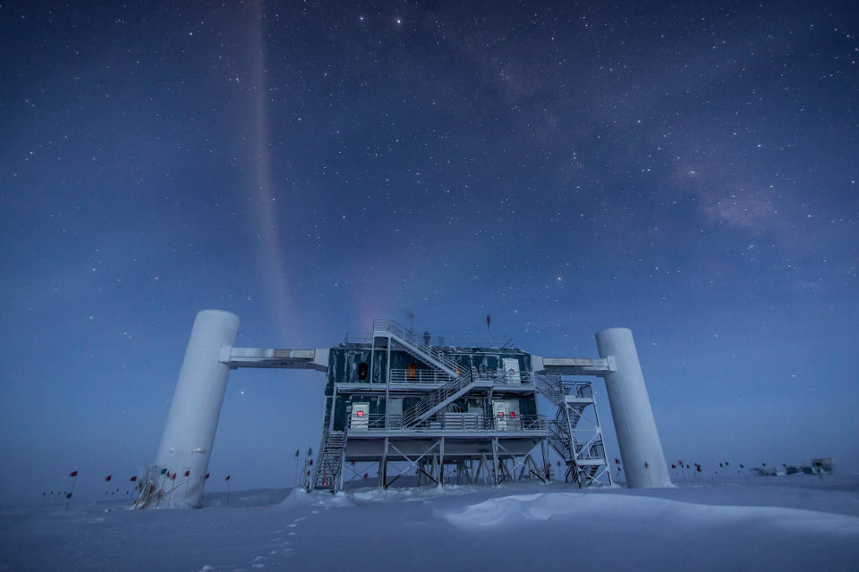 an industrial-looking metal structure covered in stairs stands alone in a snow-white landscape