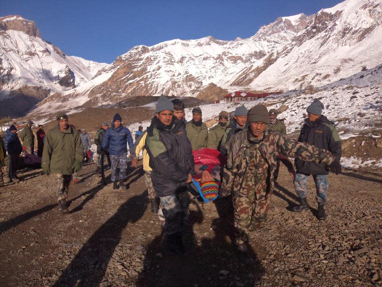 An injured survivor of a snow storm is assisted by Nepal Army personnel in Manang District, along the Annapurna Circuit on October 15, 2014