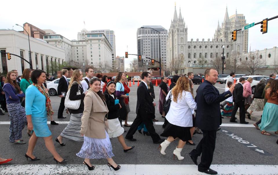People walk pass the Salt Lake Temple on the way to the Conference Center during opening session of the two-day Mormon church conference Saturday, April 5, 2014, in Salt Lake City. More than 100,000 Latter-day Saints are expected in Salt Lake City this weekend for the church's biannual general conference. Leaders of The Church of Jesus Christ of Latter-day Saints give carefully crafted speeches aimed at providing members with guidance and inspiration in five sessions that span Saturday and Sunday. They also make announcements about church statistics, new temples or initiatives. In addition to those filling up the 21,000-seat conference center during the sessions, thousands more listen or watch around the world in 95 languages on television, radio, satellite and Internet broadcasts. (AP Photo/Rick Bowmer)