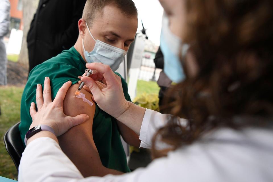 Colleen Teevan, System Pharmacy Clinical Manager at Hartford HealthCare, administers the Pfizer-BioNTech vaccine for COVID-19 to healthcare worker Connor Paleski outside of Hartford Hospital on Dec. 14, 2020, in Hartford, Conn.