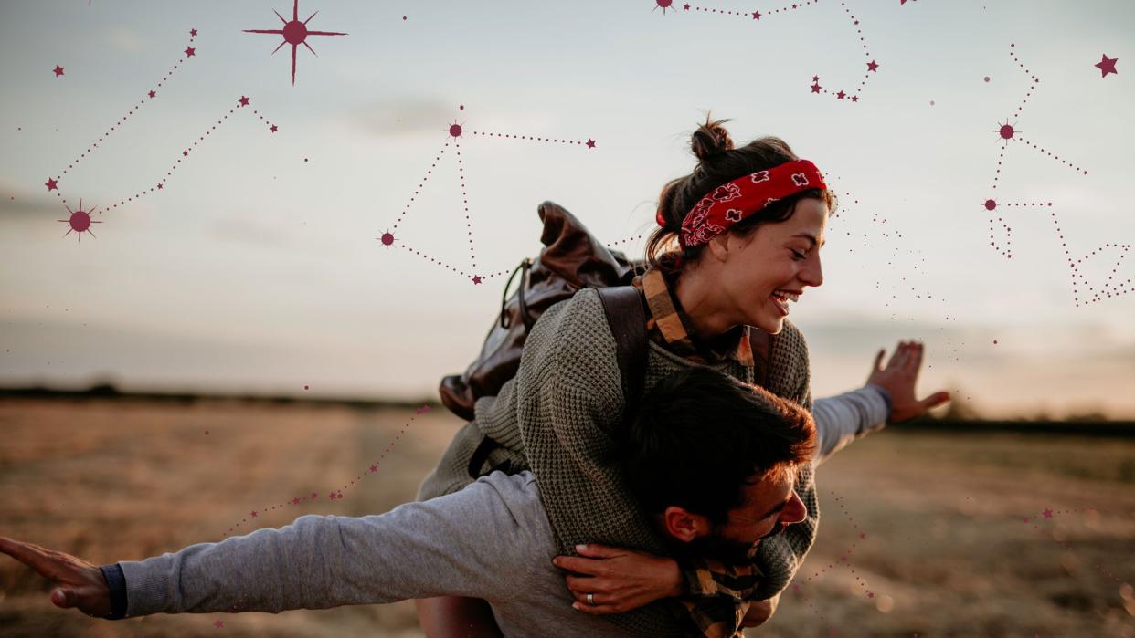 Photo of a laughing couple playing in a field with graphic-designed star chart overlayed in the the background