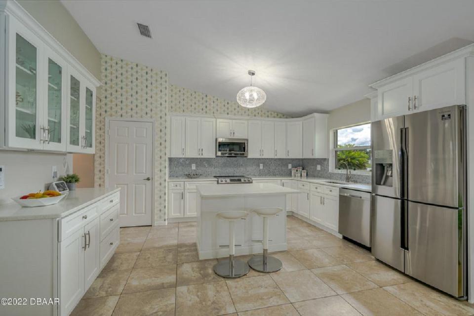 The kitchen was recently updated with gorgeous shaker-style cabinetry, including glass-display cabinets, quartz countertops, stunning glass-tile backsplash, stainless-steel appliances and a center-island breakfast bar.