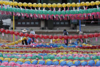 Workers wearing face masks to help protect against the spread of the new coronavirus remove lanterns after celebrations of Buddha's birthday at the Chogyesa temple in Seoul, Monday, June 29, 2020. This year a ceremony to celebrate the birthday was put off from April 30 to May 30 due to the coronavirus. (AP Photo/Ahn Young-joon)