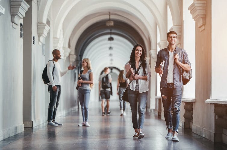 Students in a white hallway.