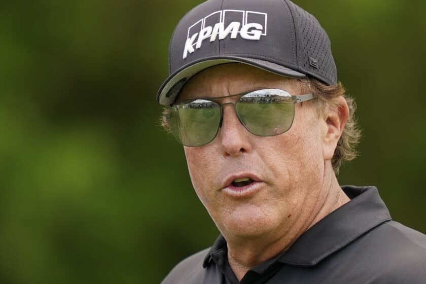 Phil Mickelson greets spectators as he walks onto the 16th tee at the Northern Trust golf tournament