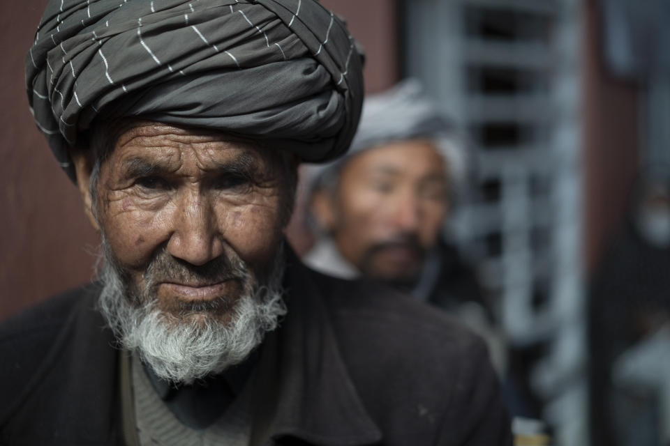 A man waits in a line to receive cash at a money distribution organized by the World Food Program (WFP) in Kabul, Afghanistan, Wednesday, Nov. 3, 2021. Since the Taliban swept into power, Afghanistan's economy has been crumbling. (AP Photo/Bram Janssen)