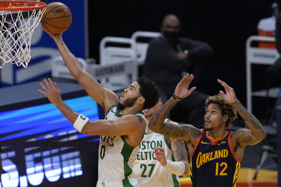 Boston Celtics forward Jayson Tatum, left, shoots next to Golden State Warriors guard Kelly Oubre Jr. (12) during the first half of an NBA basketball game in San Francisco, Tuesday, Feb. 2, 2021. (AP Photo/Jeff Chiu)