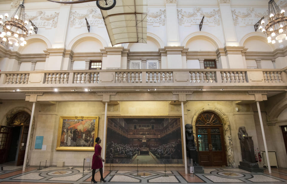 A passer-by views the painting 'Devolved Parliament' by the graffiti artist Banksy, which is going on show at Bristol Museum.