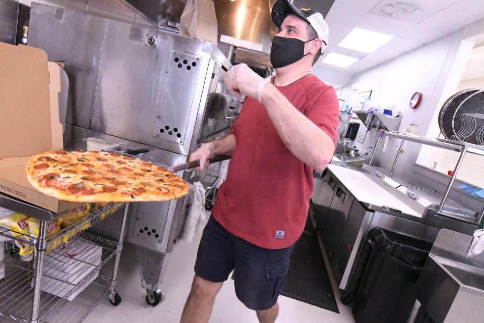 Jay Kranchalk pulls a fresh pepperoni and mushroom pizza out of the oven to be served for lunch at Fat Daddy's Pizza in Burgaw, N.C. The pizza shop opened in August of 2020 as part of the Burgaw Now initiative and is serving up pizza, garlic knots, blueberry knots, and Stromboli to the excitement of the local residents. [KEN BLEVINS/STARNEWS]