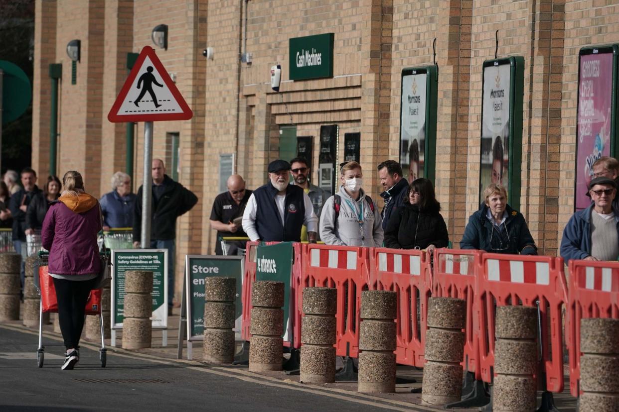 Customers queue outside a supermarket in Whitley Bay: PA