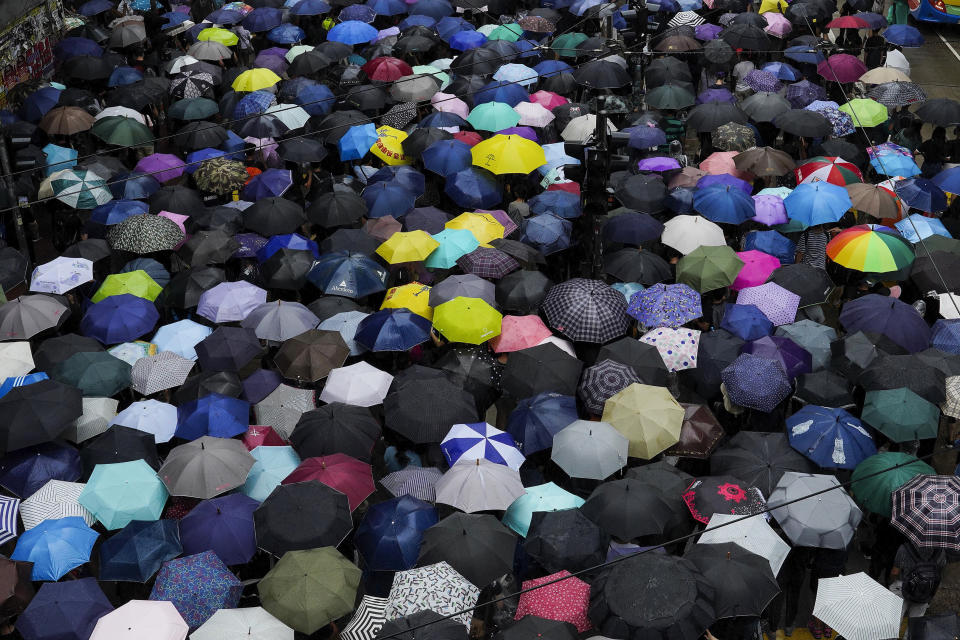 Protesters carrying umbrellas march on a street in a rainy day in Hong Kong, Sunday, Oct. 6, 2019. Thousands of protesters braved the rain to march in central Hong Kong as a second legal attempt to block a mask ban at rallies to quash four months of pro-democracy demonstrations was rejected by the court. (AP Photo/Vincent Yu)