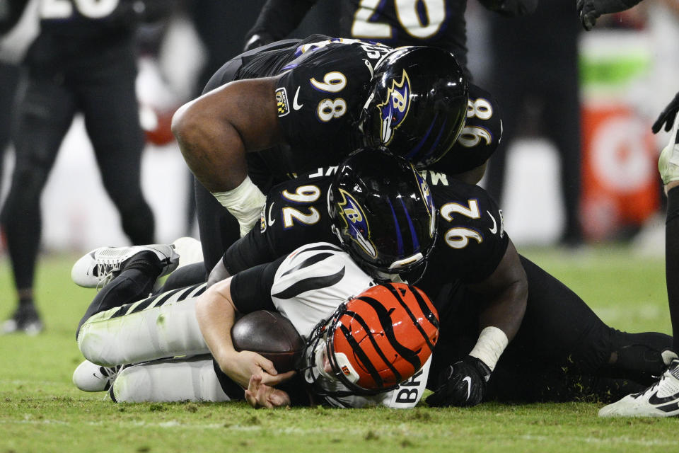 Cincinnati Bengals quarterback Jake Browning (6) is tackled by Baltimore Ravens defensive tackle Travis Jones (98) and Baltimore Ravens defensive tackle Justin Madubuike (92). (AP Photo/Nick Wass)
