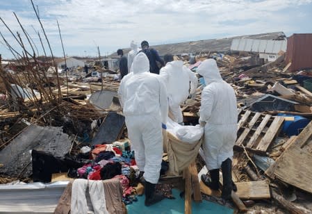 Members of the Bahamian Defense Force remove bodies from the destroyed Abaco shantytown called Pigeon Peas