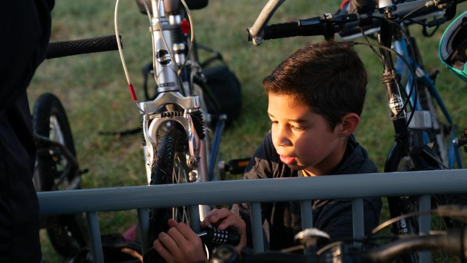 Liam Caitlin attaches a lock to his bicycle in Edwardsville, Ill. on Oct. 6, 2023 after riding to school on a “bike bus” consisting of four other children and two adult supervisors.