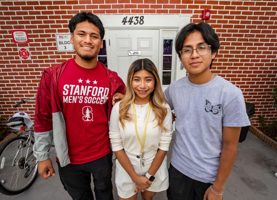 Christian Cortes-Daza, left, and Freddy Bautista-Molina stand with Brenda Alvarez-Lagunas, the coordinator of after-school programs at the RCMA Mulberry Community Academy. Alvarez-Lagunas graduated last year from Stanford University, and the two high school seniors are now headed to prestigious colleges as well.