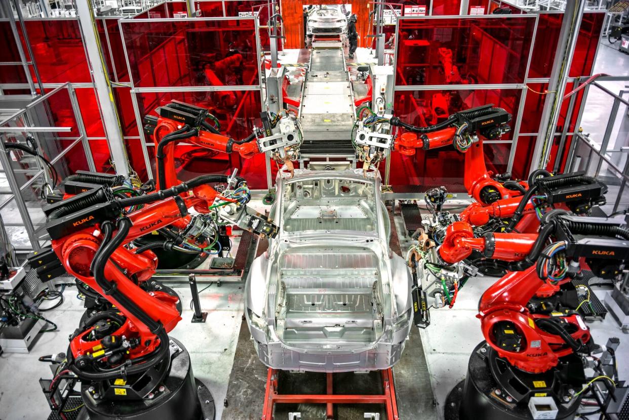 Robotic arms operate on a Tesla Model S production line at the Tesla factory in Fremont, Calif.