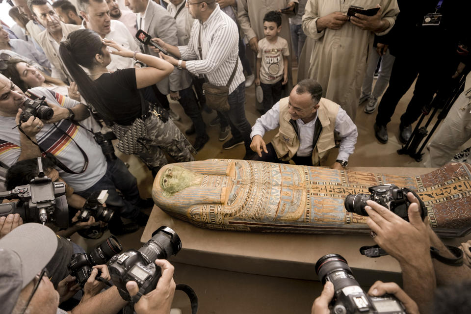 Mostafa Waziri, secretary-general of the Supreme Council of Antiquities, displays a recently unearthed ancient wooden sarcophagus at the site of the Step Pyramid of Djoser in Saqqara, 24 kilometers (15 miles) southwest of Cairo, Egypt, Saturday, May 27, 2023. Saqqara is a part of Egypt's ancient capital of Memphis, a UNESCO World Heritage site. Waziri said the workshops had been used to mummify humans and sacred animals, dated back to the 30th Pharaonic Dynasty 380 BC to 343 BC and Ptolemaic period 305 BC to 30 BC. (AP Photo/Amr Nabil)