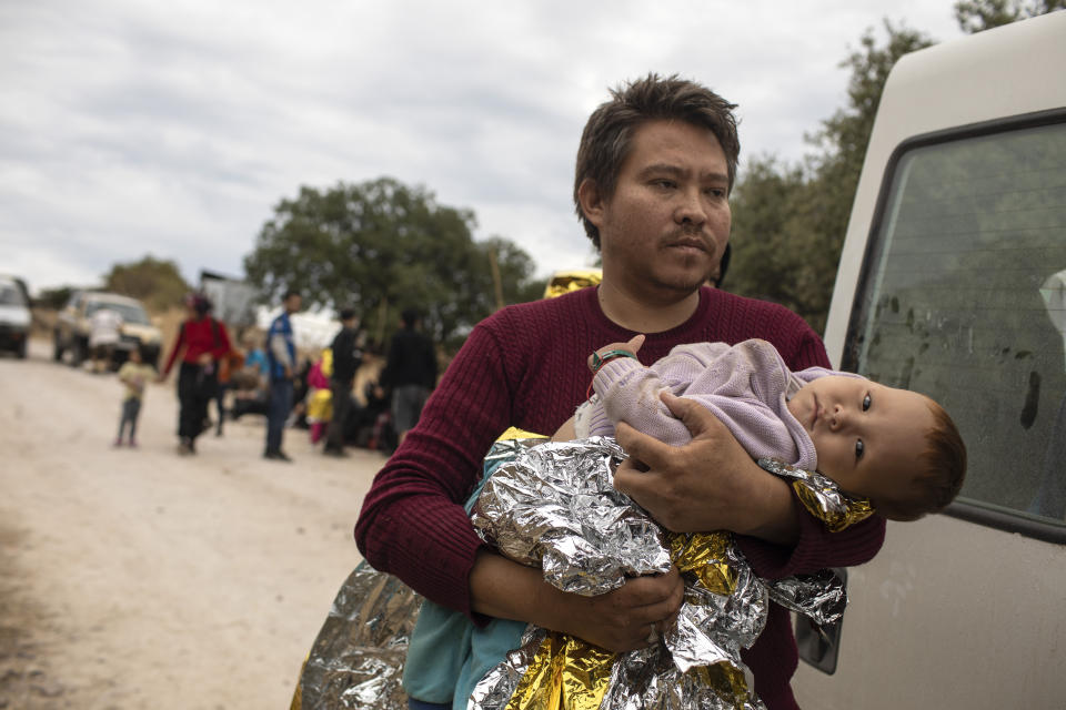 An Afghan man with his baby arrives with other migrants and refugees after crossing a part of the Aegean Sea, from Turkey to Greece on an overcrowded dinghy, near the town of Madamados on the Greek island of Lesbos, on Monday, Oct. 7, 2019. Authorities in Greece have expanded a program to transfer migrants and refugees from overcrowded camps on the islands to the mainland amid concern that the number of arrivals from nearby Turkey could continue to rise. (AP Photo/Petros Giannakouris)