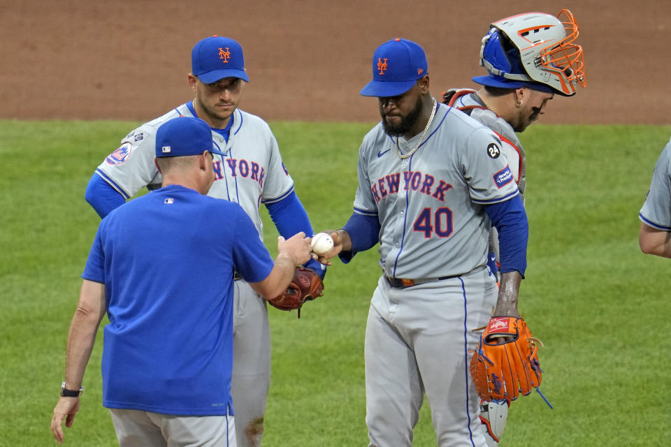 New York Mets starting pitcher Luis Severino (40) hands the ball to manager Carlos Mendoza, left, as he leaves the baseball game against the Pittsburgh Pirates during the seventh inning in Pittsburgh, Friday, July 5, 2024. (AP Photo/Gene J. Puskar)