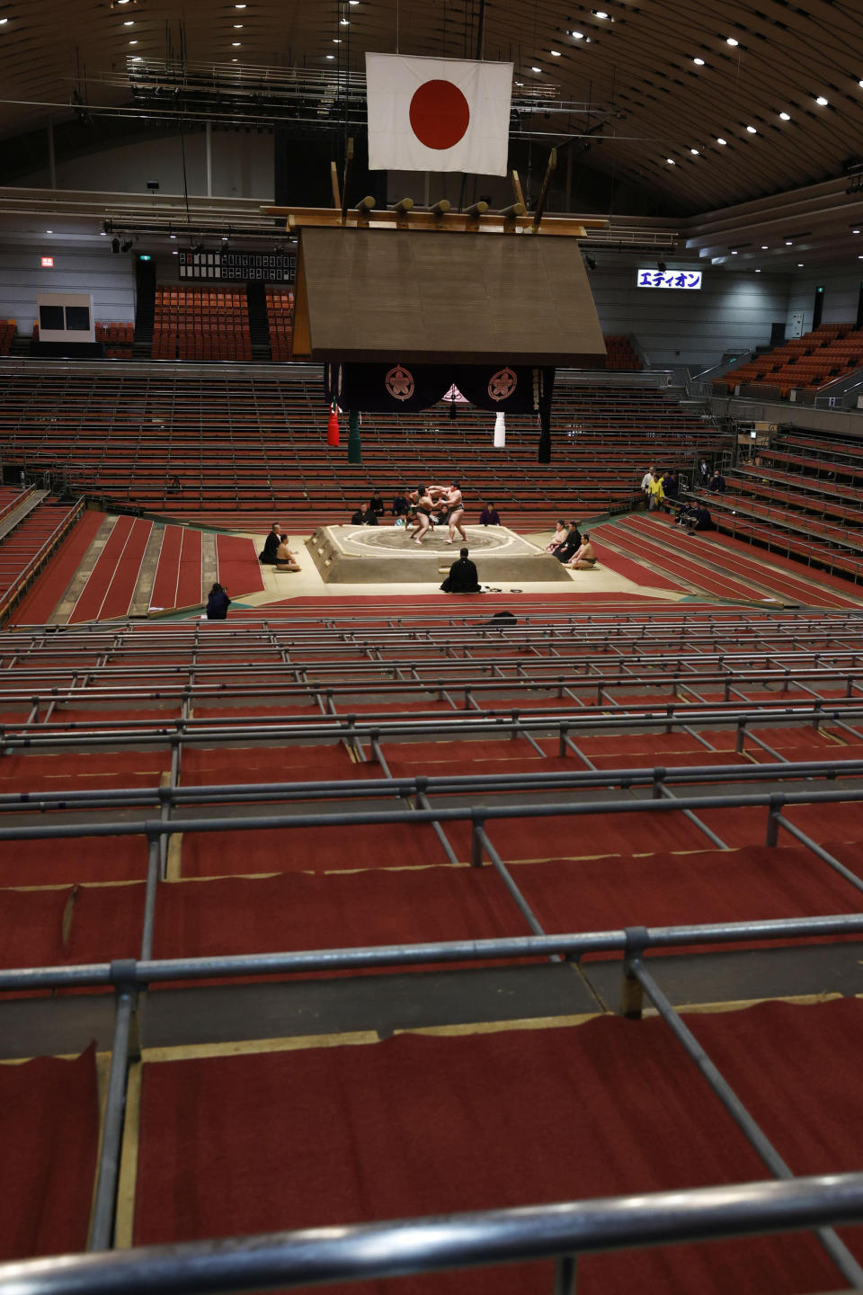 Spectators' seats are empty during a fight between sumo wrestlers at the Spring Grand Sumo Tournament in Osaka, western Japan, Sunday, March 8, 2020. The 15-day sumo tournament started on Sunday with no spectators, affected by fears of the new coronavirus outbreak. (Kyodo News via AP)