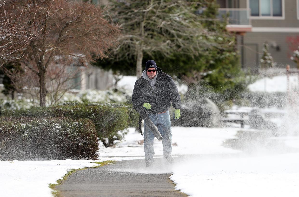 Bremerton Parks Department’s Mike Kelly blows the snow off of the pathway at Lions Park in Bremerton on Thursday, Feb. 23, 2023. 