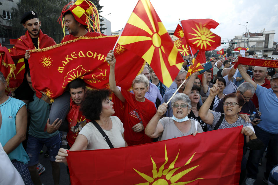 FILE - People wave the old and current national flags during a protest in front of the government building in Skopje, North Macedonia, Saturday, July 2, 2022. Nightly protests in North Macedonia over the past week have left dozens injured. At the heart of the turmoil is the small Balkan country’s long-running quest to join the European Union, a process that has faced one hurdle after the other. (AP Photo/Boris Grdanoski, File)