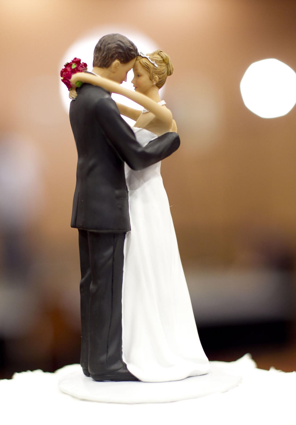 FILE - Figurines of a bride and a groom sit atop a wedding cake in Raleigh, N.C., on Tuesday May 8, 2012. A study of more than 3.5 million Americans finds that married people are less likely than singles, divorced or widowed folks to suffer any type of heart or blood vessel problem. The results were released Friday, March 28, 2014. (AP Photo/The News & Observer, Robert Willett)