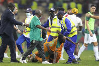 Ivory Coast's Max Gradel, tbottom, is pulled down a fan who invaded the playing field at the end of the African Cup of Nations 2022 group E soccer match between Ivory Coast and Algeria at the Japoma Stadium in Douala, Cameroon, Thursday, Jan. 20, 2022. (AP Photo/Themba Hadebe)