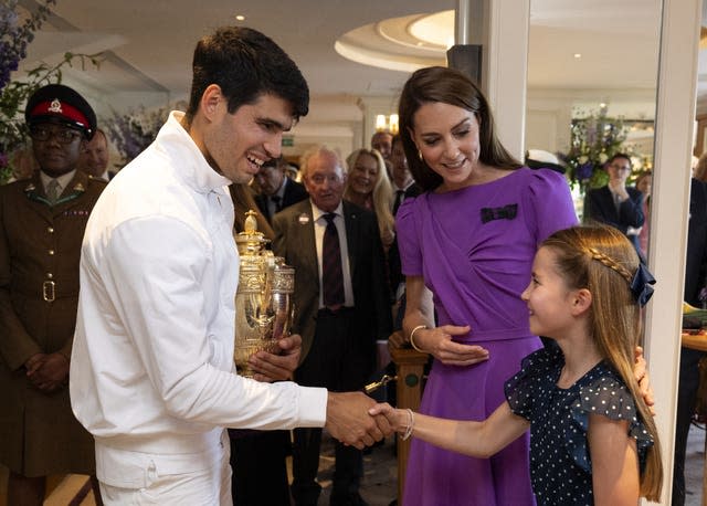 The Princess of Wales, patron of the All England Lawn Tennis Club, looks on as Princess Charlotte shakes hands with Carlos Alcaraz